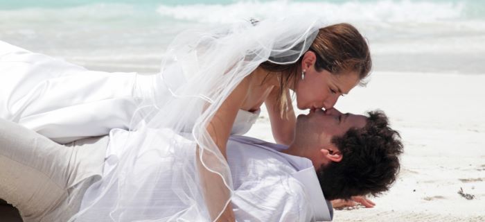 Married couple kissing each other on the beach